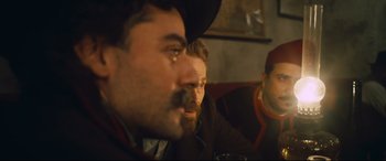 Movie still from “At Eternity's Gate” (2018), directed by Julian Schnabel – A man with a mustache and a hat on sitting next to another man with a mustache; Close Up shot, Over the shoulder angle