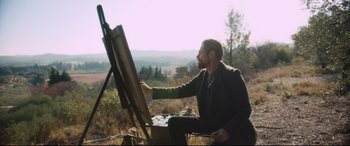 Movie still from “At Eternity's Gate” (2018), directed by Julian Schnabel – A man painting a picture on an easel outside; Wide shot, Low angle