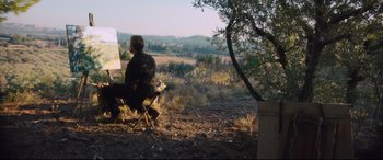 Movie still from “At Eternity's Gate” (2018), directed by Julian Schnabel – A man sitting in a chair in the middle of a field; Extreme Wide shot, High angle
