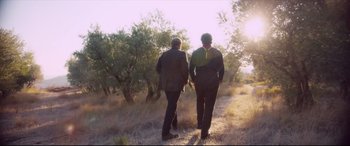 Movie still from “At Eternity's Gate” (2018), directed by Julian Schnabel – Two men are walking in the grass near some trees; Wide shot, Over the shoulder angle
