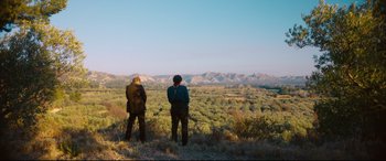 Movie still from “At Eternity's Gate” (2018), directed by Julian Schnabel – Two men standing on a hill looking at the mountains; Extreme Wide shot, Low angle