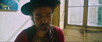 Movie still from “At Eternity's Gate” (2018), directed by Julian Schnabel – A man with a beard and a green hat; Close Up shot, Low angle