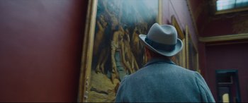 Movie still from “At Eternity's Gate” (2018), directed by Julian Schnabel – A man wearing a hat looking at a painting; Medium shot, Over the shoulder angle
