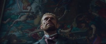 Movie still from “At Eternity's Gate” (2018), directed by Julian Schnabel – A person wearing a suit and tie; Medium shot, Low angle