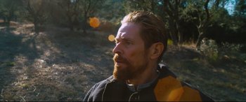 Movie still from “At Eternity's Gate” (2018), directed by Julian Schnabel – A man with a beard is standing in the woods; Close Up shot, Over the shoulder angle