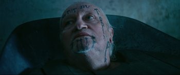 Movie still from “At Eternity's Gate” (2018), directed by Julian Schnabel – An old man with a tattoo on his face; Close Up shot, Overhead angle