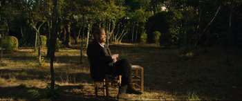 Movie still from “At Eternity's Gate” (2018), directed by Julian Schnabel – A man sitting on a chair in the middle of a field; Wide shot, Over the shoulder angle