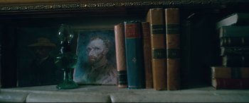 Movie still from “At Eternity's Gate” (2018), directed by Julian Schnabel – A painting of a man on a shelf next to some books; Extreme Close Up shot, High angle