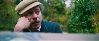Movie still from “At Eternity's Gate” (2018), directed by Julian Schnabel – A person wearing a hat with trees in the background; Close Up shot, Low angle