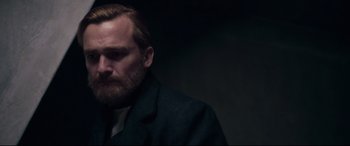 Movie still from “At Eternity's Gate” (2018), directed by Julian Schnabel – A person wearing a suit and tie; Close Up shot, Over the shoulder angle