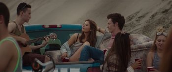 Movie still from “At First Light” (2018), directed by Jason Stone – A woman sitting in the back of a car next to a man; Medium shot, Over the shoulder angle