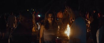 Movie still from “At First Light” (2018), directed by Jason Stone – A woman standing in front of a crowd of people; Medium shot, Over the shoulder angle