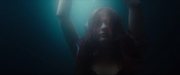 Movie still from “At First Light” (2018), directed by Jason Stone – A woman with long red hair is swimming underwater; Medium shot, Low angle