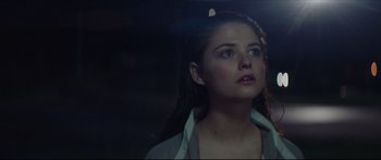 Movie still from “At First Light” (2018), directed by Jason Stone – A young woman looking up into the air; Close Up shot, Low angle