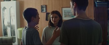 Movie still from “At First Light” (2018), directed by Jason Stone – A group of people standing in front of a mirror; Medium shot, Over the shoulder angle