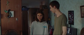 Movie still from “At First Light” (2018), directed by Jason Stone – A young man and a young woman standing next to each other; Medium shot, Over the shoulder angle