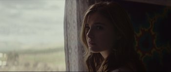 Movie still from “At First Light” (2018), directed by Jason Stone – A woman looking out a window at the outside; Close Up shot, Low angle