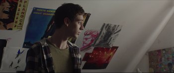 Movie still from “At First Light” (2018), directed by Jason Stone – A man standing in front of a bunch of pictures; Close Up shot, Over the shoulder angle