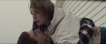 Movie still from “At First Light” (2018), directed by Jason Stone – A young man and a young woman laying on the ground; Close Up shot, Low angle