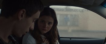 Movie still from “At First Light” (2018), directed by Jason Stone – A man and a woman sitting in a car looking sad; Close Up shot, Over the shoulder angle