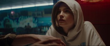 Movie still from “At First Light” (2018), directed by Jason Stone – A woman wearing a hooded sweatshirt looking at the camera; Close Up shot, Over the shoulder angle