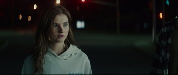 Movie still from “At First Light” (2018), directed by Jason Stone – A woman in a white hoodie standing in the dark; Close Up shot, Over the shoulder angle
