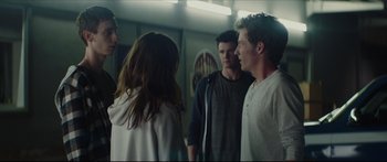 Movie still from “At First Light” (2018), directed by Jason Stone – A group of people standing next to each other in a room; Medium shot, Over the shoulder angle