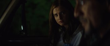 Movie still from “At First Light” (2018), directed by Jason Stone – A woman with long brown hair stares into the camera; Close Up shot, Over the shoulder angle