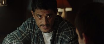 Movie still from “At First Light” (2018), directed by Jason Stone – A person wearing a plaid shirt; Close Up shot, Over the shoulder angle
