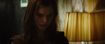 Movie still from “At First Light” (2018), directed by Jason Stone – A woman with long brown hair is looking at the camera; Close Up shot, Low angle
