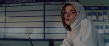 Movie still from “At First Light” (2018), directed by Jason Stone – A woman in a white hoodie is sitting in front of a computer screen; Close Up shot, Over the shoulder angle