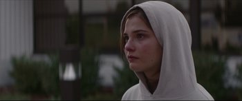 Movie still from “At First Light” (2018), directed by Jason Stone – A young woman wearing a hooded sweatshirt looking to her left; Close Up shot, Over the shoulder angle