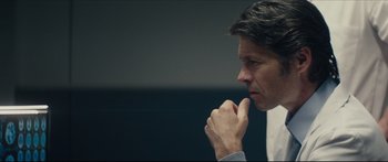 Movie still from “At First Light” (2018), directed by Jason Stone – A person holding his hand to his chin; Close Up shot, Over the shoulder angle