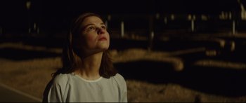 Movie still from “At First Light” (2018), directed by Jason Stone – A woman looking up into the sky at night; Close Up shot, Low angle