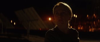 Movie still from “At First Light” (2018), directed by Jason Stone – A woman is looking up at the sky at night; Close Up shot, Over the shoulder angle