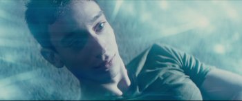 Movie still from “At First Light” (2018), directed by Jason Stone – A young man's face in a room; Close Up shot, Overhead angle