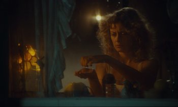 Movie still from “Atlantic City” (1980), directed by Louis Malle – A woman sitting at a table in front of a mirror; Close Up shot, Low angle