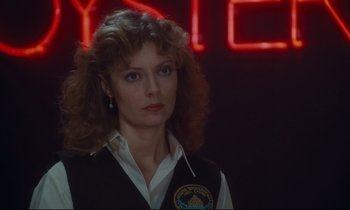 Movie still from “Atlantic City” (1980), directed by Louis Malle – A woman in front of a neon sign in front of a wall; Close Up shot, Over the shoulder angle