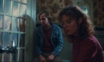 Movie still from “Atlantic City” (1980), directed by Louis Malle – A man and a woman sitting next to each other in a room; Medium shot, Low angle