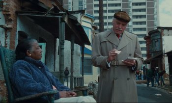 Movie still from “Atlantic City” (1980), directed by Louis Malle – An older man in a brown hat is writing something; Medium shot, Low angle