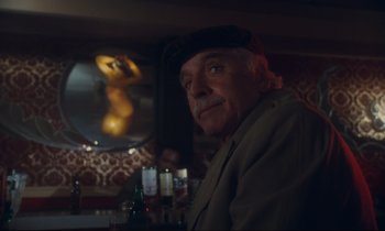 Movie still from “Atlantic City” (1980), directed by Louis Malle – An older man is sitting at a bar; Close Up shot, Low angle