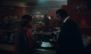 Movie still from “Atlantic City” (1980), directed by Louis Malle – Two men standing at a bar talking to each other; Medium shot, Over the shoulder angle