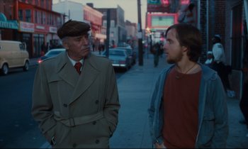 Movie still from “Atlantic City” (1980), directed by Louis Malle – A man and a boy standing on the side of the street; Medium shot, Over the shoulder angle