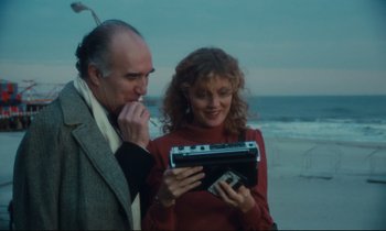 Movie still from “Atlantic City” (1980), directed by Louis Malle – A man and a woman looking at an item in a box; Medium shot, High angle