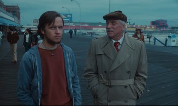 Movie still from “Atlantic City” (1980), directed by Louis Malle – A man and a boy standing next to each other on a pier; Medium shot, Over the shoulder angle