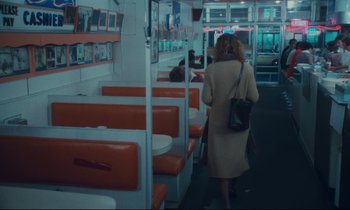 Movie still from “Atlantic City” (1980), directed by Louis Malle – A woman walking down the aisle of a diner; Wide shot, High angle