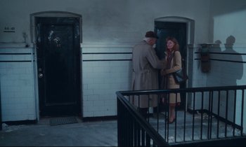 Movie still from “Atlantic City” (1980), directed by Louis Malle – A man and a woman standing next to each other in front of a door; Wide shot, High angle