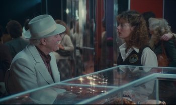 Movie still from “Atlantic City” (1980), directed by Louis Malle – A man and a woman talking to each other in front of a display case; Medium shot, Over the shoulder angle