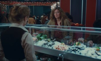 Movie still from “Atlantic City” (1980), directed by Louis Malle – A woman is looking in the mirror at a fish market; Medium shot, Over the shoulder angle