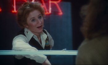 Movie still from “Atlantic City” (1980), directed by Louis Malle – A woman is sitting in front of a neon sign; Close Up shot, Over the shoulder angle